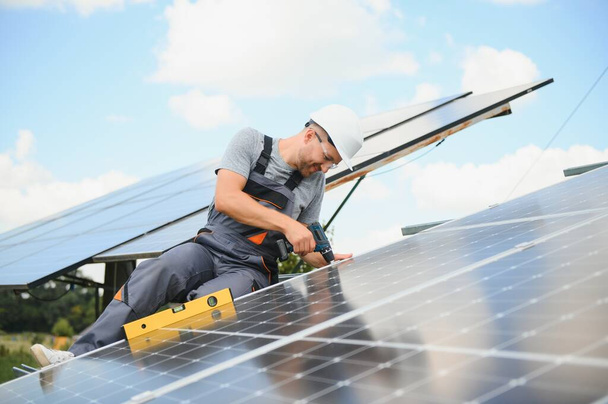Worker installing solar panels outdoors. - Фото, зображення