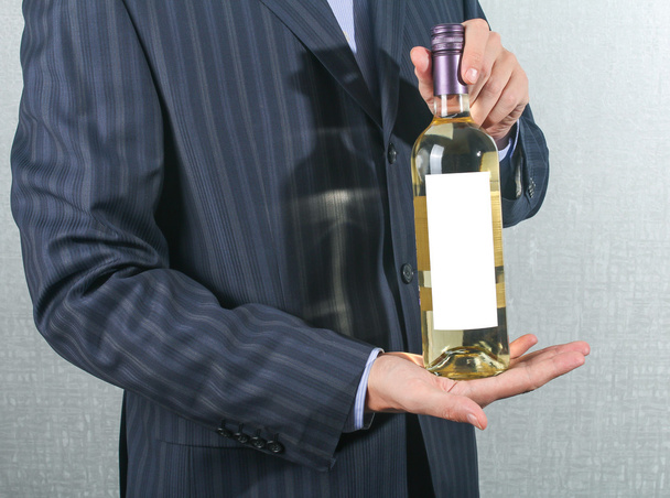 κομψό άνθρωπος που κρατά ένα μπουκάλι με κρασί - Φωτογραφία, εικόνα