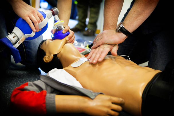First aid training: alternate use of a manual resuscitator bag followed by cardiac massage. - Foto, Bild
