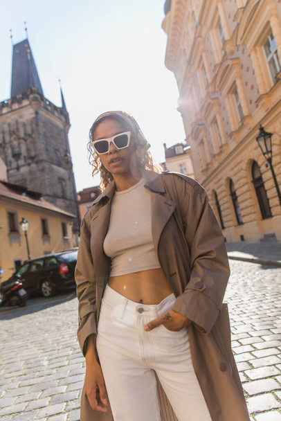 stylish african american woman posing near old town hall tower in prague - Photo, Image