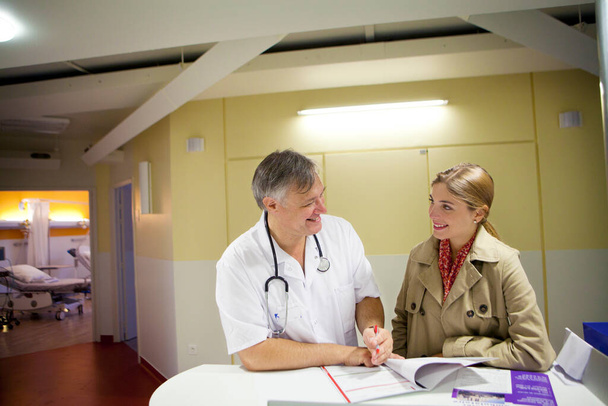 Un mdecin accueil une patiente au service de chirurgie ambulatoire.  - Foto, Imagen