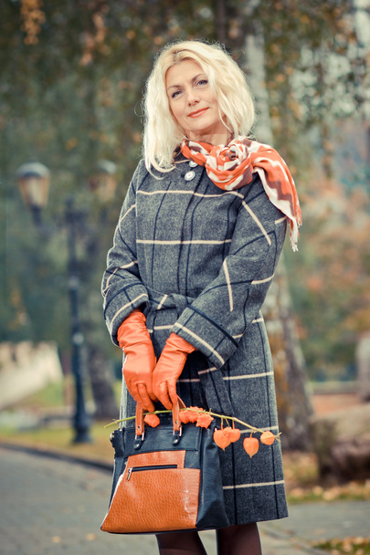 Mujer con abrigo a cuadros posando en el parque
 - Foto, Imagen