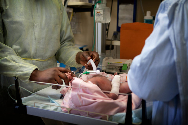 Pediatric emergencies intervene in a hospital for a newborn baby who has breathing difficulties. - Foto, Bild