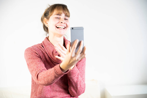 Extremely joyful woman at the sight of her new smartphone. - Fotoğraf, Görsel