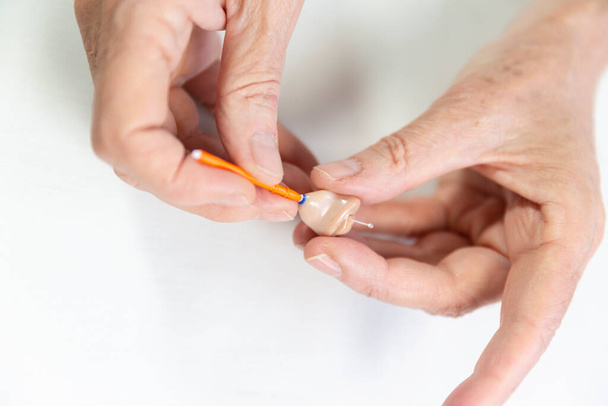 Cleaning a hearing aid. - Foto, Imagen