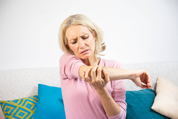 A woman in her fifties with elbow pain. - Foto, Imagem