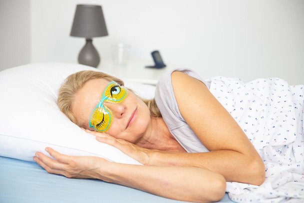 Woman wearing a sleep mask. - Photo, Image