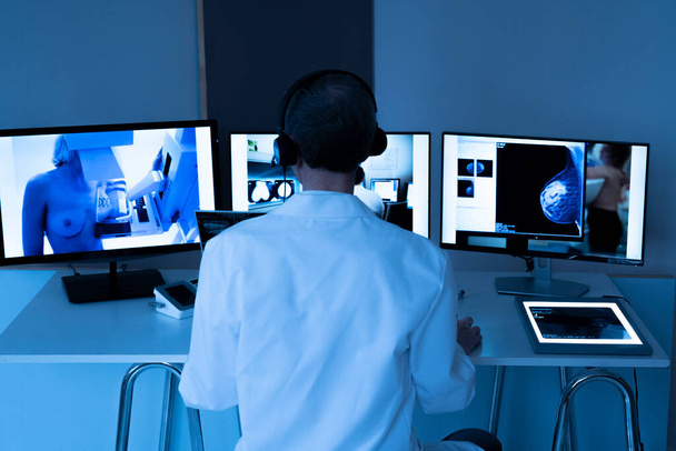 Гинеколог во время видеоконсультации с коллегой-рентгенологом для обследования груди пациента: маммография и ультразвук. - Фото, изображение