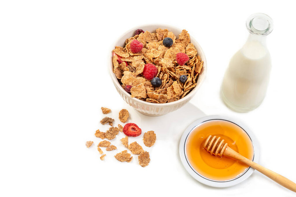 Здоровый завтрак с миской хлопьев, молока и меда. - Фото, изображение