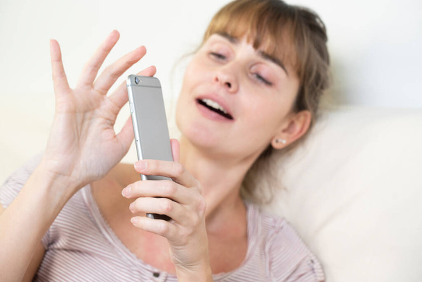 Woman worshiping her smartphone. Dependency and addiction behavior. - Photo, Image