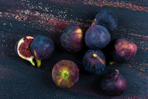 Harvest of black figs rich in minerals and trace elements on an old board.  - Foto, imagen