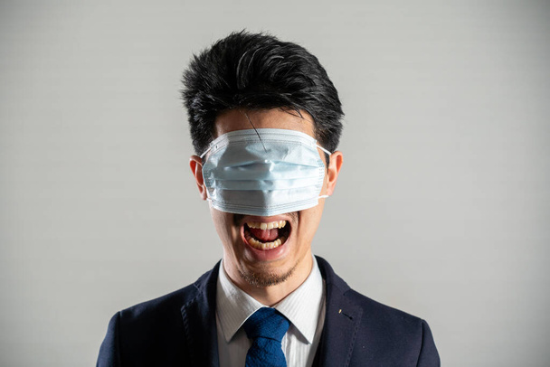Screaming man wearing a mask over his eyes - 写真・画像