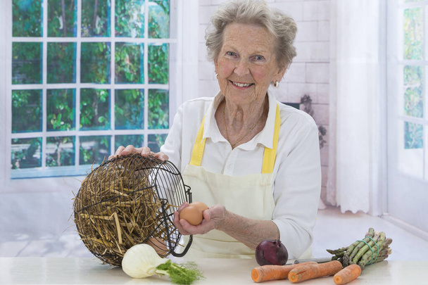 Senior woman cooking and smiling - Photo, Image