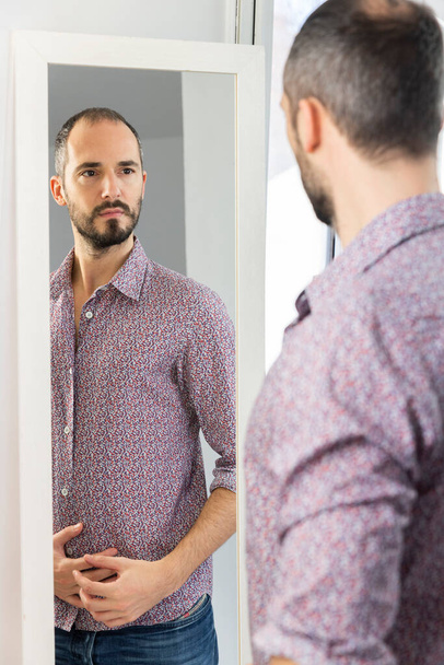 A man looking in a mirror to give him self-confidence. - Photo, Image