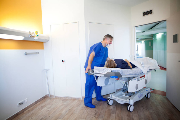 Un ambulancier emne une patiente au bloc opratoire.  - Фото, изображение