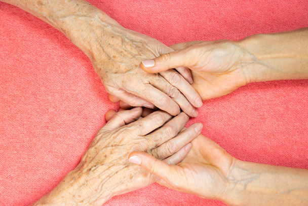 Μια ηλικιωμένη γυναίκα και νέες γυναίκες χέρια.  - Φωτογραφία, εικόνα