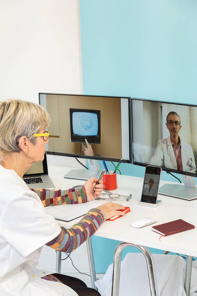 Teleconsultation between two doctors with a stem cell on one of the screens. - Photo, image