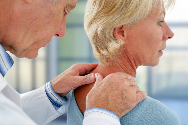 Doctor examining the neck of a patient. - Photo, image