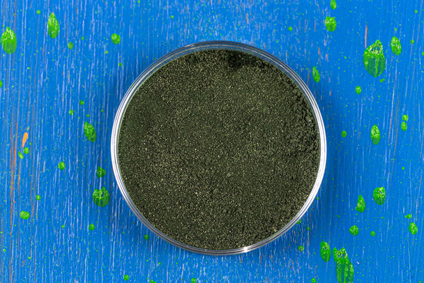 Close up of spirulina powder in a glass container top view. - Foto, immagini