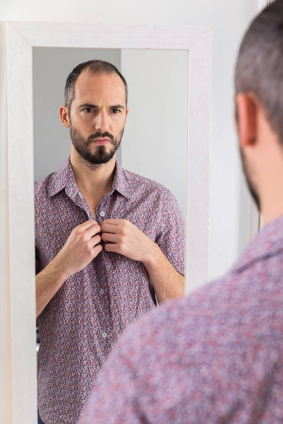 Человек, смотрящий в зеркало, чтобы придать ему уверенности в себе. - Фото, изображение