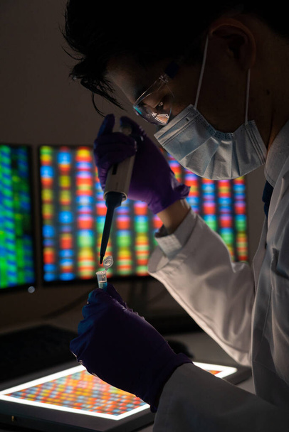 Male researcher in front of genome screens. - Foto, afbeelding