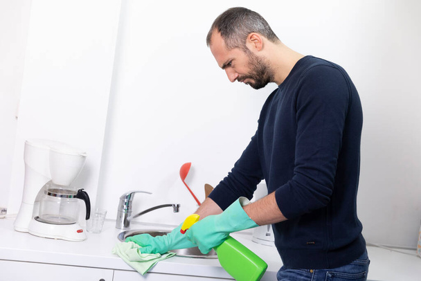 A man using cleaning products to clean. - Foto, afbeelding