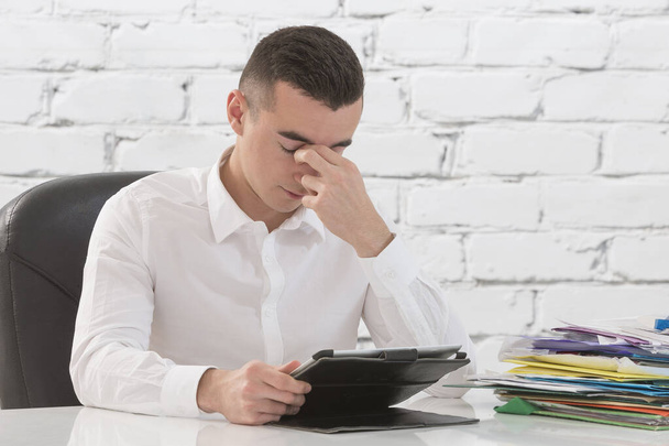 Απογοητευμένος νέος επιχειρηματίας που εργάζεται στον υπολογιστή tablet στο γραφείο - Φωτογραφία, εικόνα
