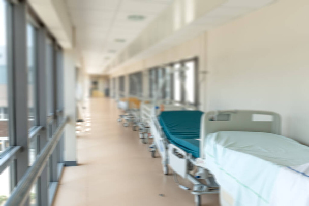 Изображение кроватей, выстроенных в коридоре больницы без медицинского персонала и пациентов. - Фото, изображение