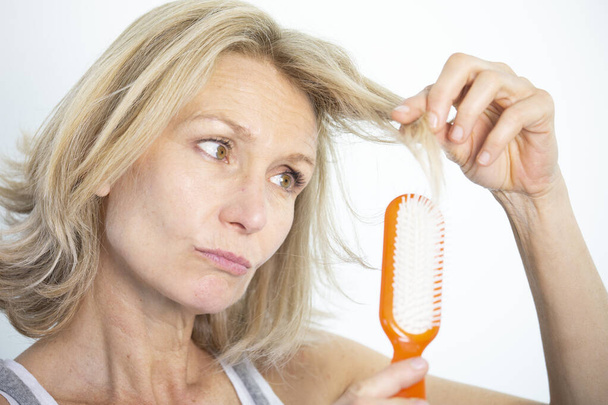 Woman looking at her split ends. - Photo, Image