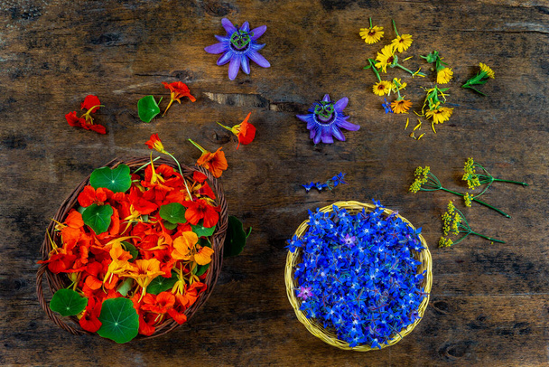 Baskets of edible flowers, nasturtiums and borage flowers used in gastronomy, view from above. - Foto, Imagen
