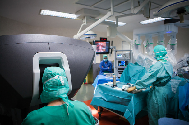 Роботизована хірургія в операційній кімнаті під час гістеректомії, робота керує хірург з консолі
. - Фото, зображення