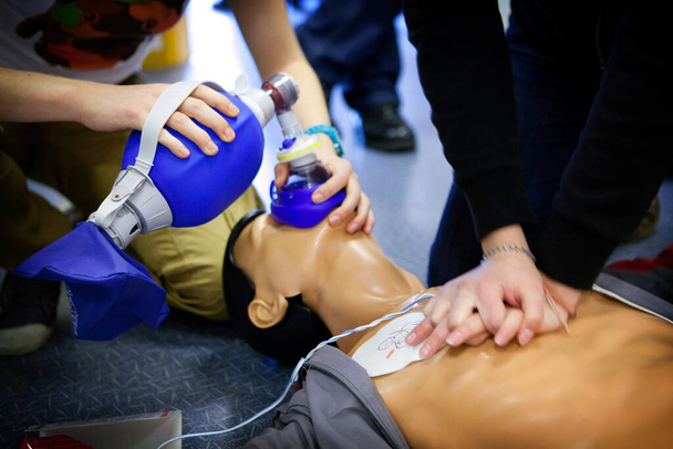 First aid training: alternate use of a manual resuscitator bag followed by cardiac massage. - Foto, imagen
