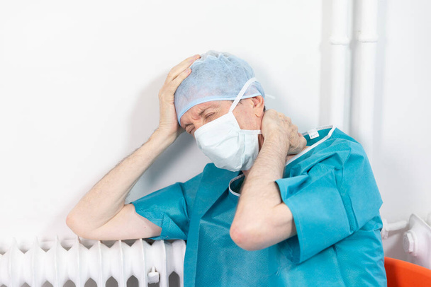 Ένας χειρουργός εξαντλημένος από τη δουλειά του. - Φωτογραφία, εικόνα