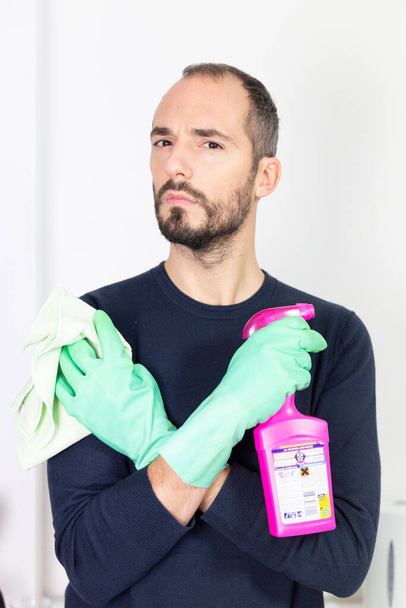 A man using cleaning products to clean. - Zdjęcie, obraz