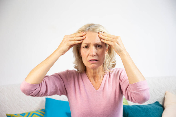 A woman in her fifties with a migraine. - Photo, image
