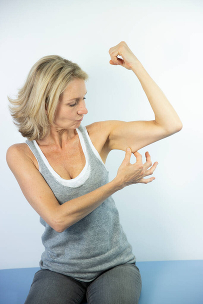 Woman looking at her muscles. - Valokuva, kuva