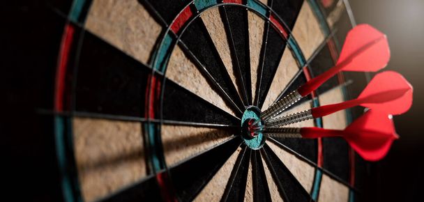 red darts in the dartboard center. business target or goal success and winner strategy concept. banner with copy space - 写真・画像