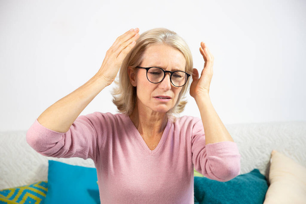 A woman in her fifties with a migraine. - Zdjęcie, obraz