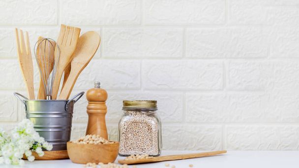 Select focus. Kitchen tools and kitchenware utensil object with ingredients and mix nut on kitchen shelf wood white for healthy eat and health care life.  Wall white brick background, copy space for text - Φωτογραφία, εικόνα