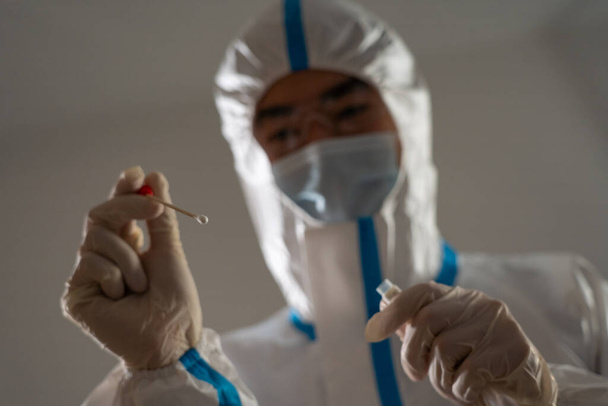 Medical personnel performing an antigen test for covid-19. - 写真・画像