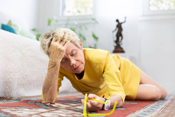An elderly woman on her floor having fallen. - Foto, Bild