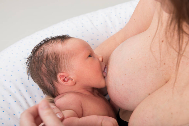 Mother breast feeding 2-week-old baby. - 写真・画像