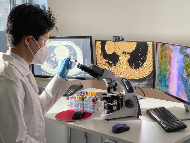 Laboratory technician doing research with images of lungs infested with Covid-19 on a computer. - Foto, Imagen