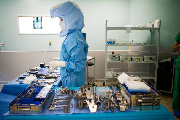 Ортопедическая хирургия, медсестра готовит хирургические инструменты для установки протеза колена. - Фото, изображение