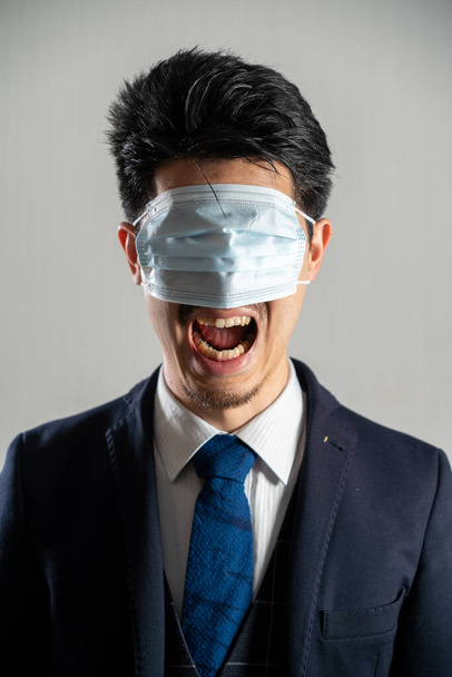 Screaming man wearing a mask over his eyes - Fotó, kép