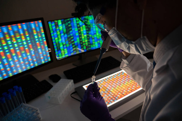 Male researcher in front of genome screens. - Foto, afbeelding