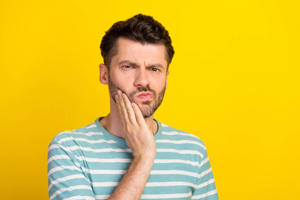 Photo of sick guy hand cheek wear striped t-shirt isolated on yellow color background. - Zdjęcie, obraz