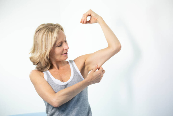 Woman looking at her muscles. - Valokuva, kuva