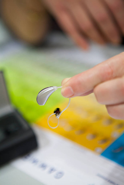 Presentation of a hearing aid to a hearing care professional. - Fotoğraf, Görsel