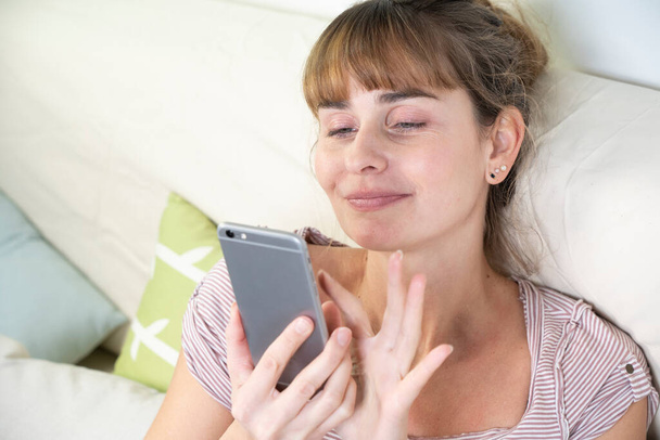 Woman worshiping her smartphone. Dependency and addiction behavior. - Foto, Bild